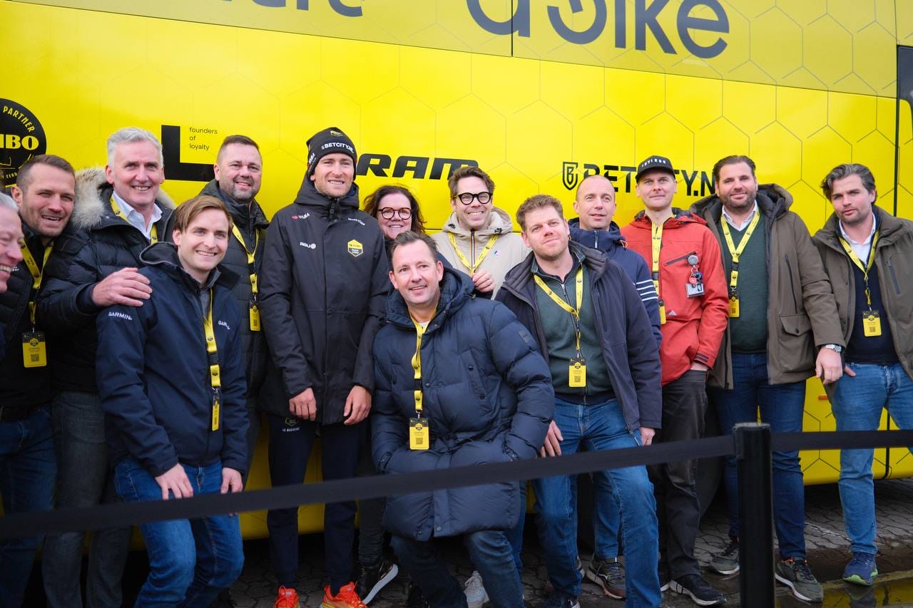 TvL experience spectators pose in front of a team bus ahead of the Tour de France 2026